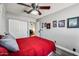 Comfortable bedroom featuring a red duvet and ceiling fan with closet at 13207 N 55Th Ave, Glendale, AZ 85304