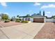 Well-kept home with a long driveway, beautiful landscaping, and a cozy covered seating area at 13207 N 55Th Ave, Glendale, AZ 85304