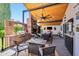 Outdoor patio area with ceiling fan, fireplace, and outdoor kitchen with seating and tv at 13207 N 55Th Ave, Glendale, AZ 85304