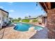 Serene backyard pool with a rock feature, lush landscaping, and ample patio space at 13207 N 55Th Ave, Glendale, AZ 85304