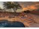 Stunning backyard pool and spa with waterfall and rock features, set against a picturesque sunset backdrop at 14056 E Desert Cove Ave, Scottsdale, AZ 85259