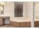 Bright bathroom features a soaking tub with tile surround, vanity with mirror, and large window at 14056 E Desert Cove Ave, Scottsdale, AZ 85259