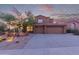 Charming two-story home with a three car garage and desert landscaping under a colorful sunset sky at 14056 E Desert Cove Ave, Scottsdale, AZ 85259