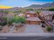 Aerial view of a desert home featuring a large driveway, lush landscaping, and a three-car garage at 14056 E Desert Cove Ave, Scottsdale, AZ 85259
