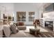 Modern living room with comfortable seating, a fireplace, and bright windows offering views of the backyard at 14056 E Desert Cove Ave, Scottsdale, AZ 85259