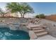 Gorgeous pool and spa combination with rock features, a stone staircase, and lush desert landscaping at 14056 E Desert Cove Ave, Scottsdale, AZ 85259