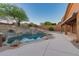 Stunning backyard oasis with a gunite pool, rock waterfall, desert landscaping, and covered patio at 14056 E Desert Cove Ave, Scottsdale, AZ 85259
