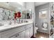 Bright bathroom featuring double sinks, white cabinets, and neutral décor at 14112 W Larkspur Dr, Surprise, AZ 85379