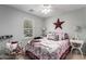 Cozy bedroom with patriotic decor, a ceiling fan, and a window providing natural light at 14112 W Larkspur Dr, Surprise, AZ 85379
