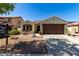 Charming single-story home features a well-manicured front yard, a two-car garage, and desert landscaping at 14112 W Larkspur Dr, Surprise, AZ 85379