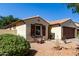 Single-story home featuring a two-car garage, desert landscaping, and stylish exterior shutters at 14112 W Larkspur Dr, Surprise, AZ 85379