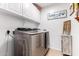 Modern laundry room with front-load washer and dryer, bright cabinetry, and stylish decor at 14112 W Larkspur Dr, Surprise, AZ 85379