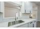 Bright kitchen featuring white cabinets, subway tile backsplash, and stainless steel sink with modern faucet at 1519 E Indian Wells Dr, Chandler, AZ 85249