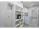 Spacious laundry room includes ample shelving and storage cabinets for maximum organization and convenience at 1519 E Indian Wells Dr, Chandler, AZ 85249