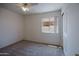 A bedroom with neutral carpet, a ceiling fan and light, plus a window and a closet with bi-fold doors at 15701 N Bonow Dr, Surprise, AZ 85374