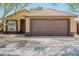 Charming single-story home with neutral stucco, tiled roof, and a two-car garage at 15701 N Bonow Dr, Surprise, AZ 85374