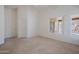 Primary bedroom with neutral carpet, window views, ceiling fan, and ensuite at 15701 N Bonow Dr, Surprise, AZ 85374