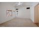 Spacious Primary bedroom with neutral carpet, ceiling fan, and multiple window views at 15701 N Bonow Dr, Surprise, AZ 85374