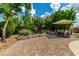 Landscaped backyard with a rock garden, brick patio, and mature trees at 16823 S 24Th Pl, Phoenix, AZ 85048