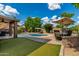 Lush backyard featuring a freeform pool, mature trees, and an outdoor dining area at 16823 S 24Th Pl, Phoenix, AZ 85048