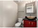 Powder room features a unique vessel sink, red vanity, and modern fixtures at 16823 S 24Th Pl, Phoenix, AZ 85048