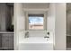 Bathtub with a window, gray cabinets, and a decorative bowl sink at 16823 S 24Th Pl, Phoenix, AZ 85048