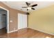 This bedroom features wood floors, a ceiling fan, and a spacious closet for ample storage at 16823 S 24Th Pl, Phoenix, AZ 85048