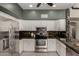 Well-lit kitchen featuring stainless steel appliances, white cabinetry, and dark countertops at 16823 S 24Th Pl, Phoenix, AZ 85048