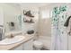 Bright bathroom with tub, shower, decorative shelves, and stylish, leafy green shower curtain at 18219 N 19Th St, Phoenix, AZ 85022