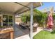 Covered patio area with patio furniture and a well-manicured lawn with green artificial turf at 18219 N 19Th St, Phoenix, AZ 85022