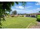 Spacious backyard with a lush green lawn and mature trees, offering ample space for outdoor activities and relaxation at 18428 N 42Nd St, Phoenix, AZ 85032