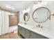 Modern bathroom with double sink vanity, round mirrors, and tiled shower at 18428 N 42Nd St, Phoenix, AZ 85032