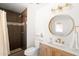 Stylish bathroom featuring a modern vanity, a round mirror, and a beautifully tiled shower at 18428 N 42Nd St, Phoenix, AZ 85032