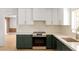 Modern kitchen features stainless steel appliances and stylish green cabinetry, flows into living space at 18428 N 42Nd St, Phoenix, AZ 85032