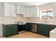 Modern kitchen features stainless steel appliances, stylish green cabinetry, and white countertops at 18428 N 42Nd St, Phoenix, AZ 85032