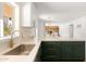 Modern kitchen with stainless steel sink, stylish green cabinetry, and view of living space at 18428 N 42Nd St, Phoenix, AZ 85032