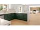 Modern kitchen features green cabinets and white countertops, open floor plan to living space at 18428 N 42Nd St, Phoenix, AZ 85032