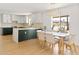 Bright kitchen features white cabinets with gold hardware, an island, and a dining area with a window view at 18428 N 42Nd St, Phoenix, AZ 85032