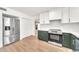 Modern kitchen featuring stainless steel appliances, plenty of white cabinets, and laminate flooring at 18428 N 42Nd St, Phoenix, AZ 85032