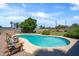 Tranquil backyard showcasing a pristine pool, lush green lawn, and cozy lounge chairs, perfect for relaxation at 18428 N 42Nd St, Phoenix, AZ 85032