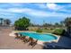 Serene backyard featuring a lovely pool, manicured lawn, mature trees, and a cozy seating area for outdoor enjoyment at 18428 N 42Nd St, Phoenix, AZ 85032