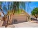 View of the home's terracotta tile roof and two car garage with low maintenance desert landscaping at 2015 E Glenhaven Dr, Phoenix, AZ 85048