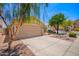 A cozy house with a spacious driveway, xeriscaping, and mature trees providing shade and curb appeal at 2015 E Glenhaven Dr, Phoenix, AZ 85048