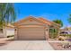 Single-story home with desert landscaping, arched window, two-car garage, and terracotta tile roof against a clear blue sky at 2015 E Glenhaven Dr, Phoenix, AZ 85048