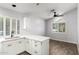 Bright kitchen features white cabinetry, counter seating, and a modern ceiling fan at 2015 E Glenhaven Dr, Phoenix, AZ 85048