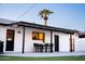 Charming outdoor dining area features a sleek table and chairs beneath a string-lit patio cover at 2023 N 79Th Pl, Scottsdale, AZ 85257