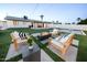 Spacious backyard featuring a modern fire pit, outdoor seating, putting green and manicured lawn at 2023 N 79Th Pl, Scottsdale, AZ 85257