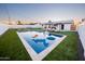 A sparkling backyard pool with a unicorn float sits amid lounge chairs and lush green landscaping at 2023 N 79Th Pl, Scottsdale, AZ 85257