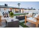 Cozy backyard featuring a modern fire pit, outdoor seating, and a well-manicured lawn with string lights at 2023 N 79Th Pl, Scottsdale, AZ 85257