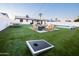 Large backyard featuring ping pong table, corn hole, putting green, fire pit and manicured lawn at 2023 N 79Th Pl, Scottsdale, AZ 85257